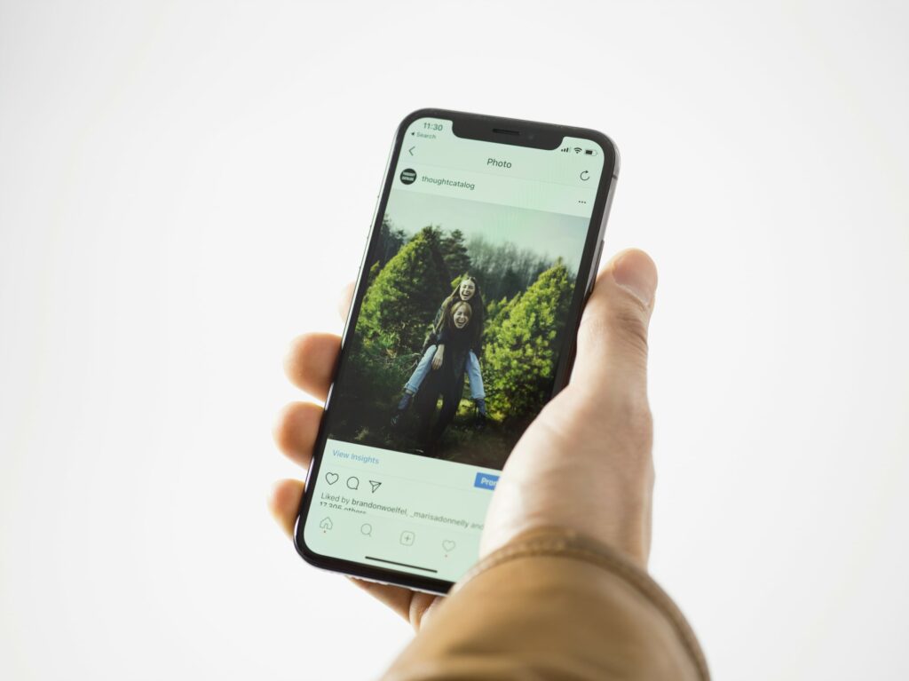 Hand hält Smartphone welches einen Instagram Beitrag anzeigt.